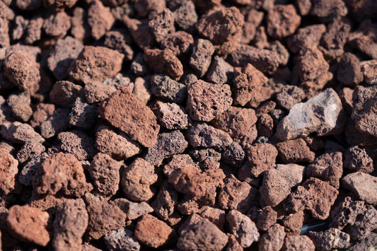 A detailed view of red lava rocks, showing their porous and rough texture